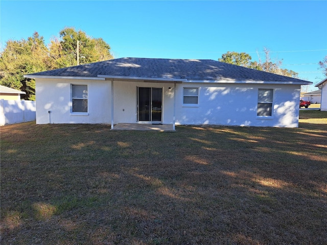 back of property featuring a lawn