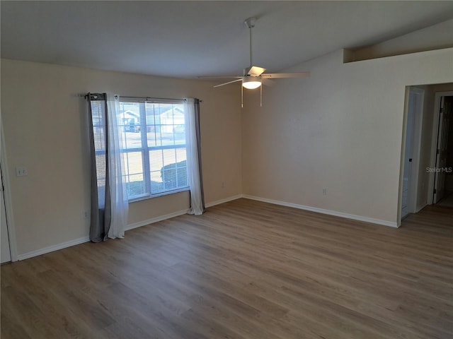 unfurnished room with ceiling fan, hardwood / wood-style floors, and lofted ceiling