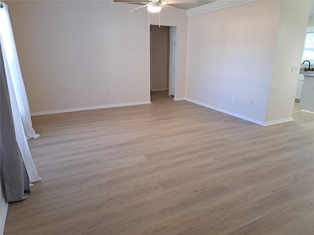 unfurnished room with light hardwood / wood-style floors, ceiling fan, and sink