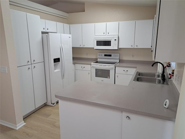 kitchen with sink, light hardwood / wood-style flooring, kitchen peninsula, white appliances, and white cabinets