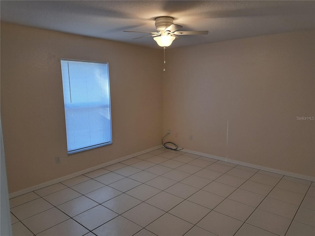 tiled spare room featuring ceiling fan