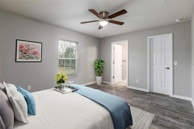 bedroom with connected bathroom, ceiling fan, and dark wood-type flooring