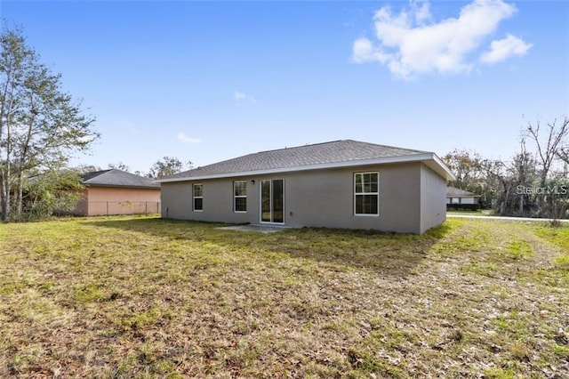 rear view of property featuring a yard