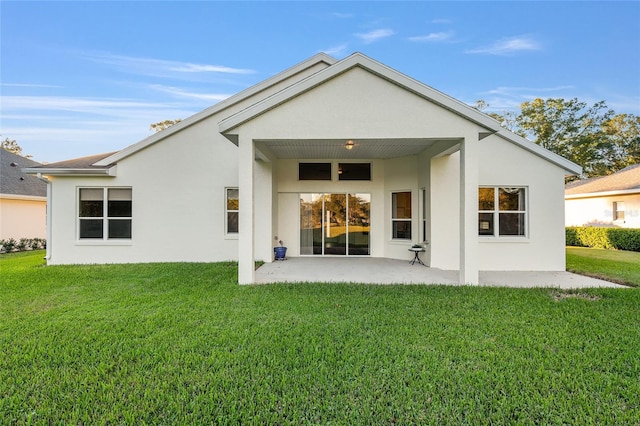 back of house with a lawn and a patio