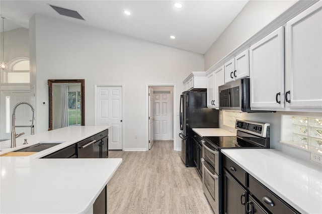 kitchen featuring stainless steel appliances, sink, light hardwood / wood-style floors, white cabinetry, and hanging light fixtures