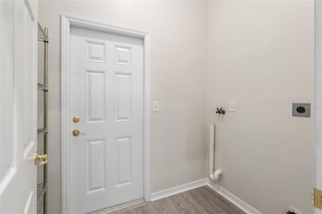 washroom with hardwood / wood-style flooring and electric dryer hookup