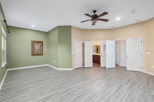 unfurnished bedroom featuring ensuite bath, ceiling fan, and light hardwood / wood-style flooring