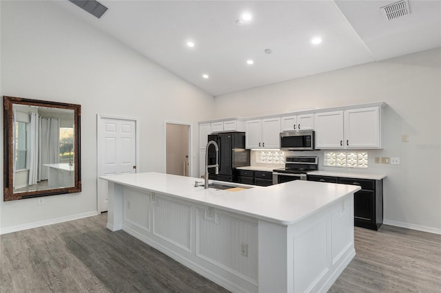 kitchen with white cabinetry, a large island, light hardwood / wood-style flooring, and stainless steel appliances