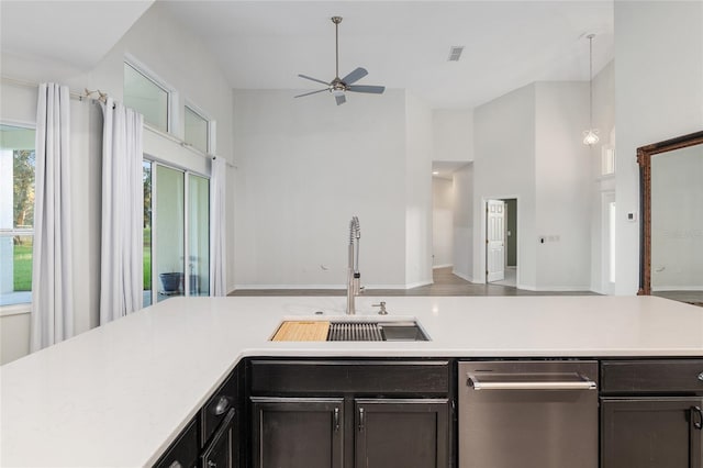 kitchen featuring a high ceiling, ceiling fan, pendant lighting, and sink