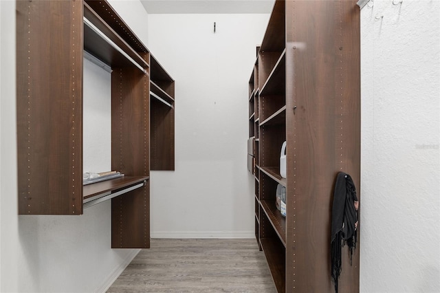 walk in closet with light wood-type flooring