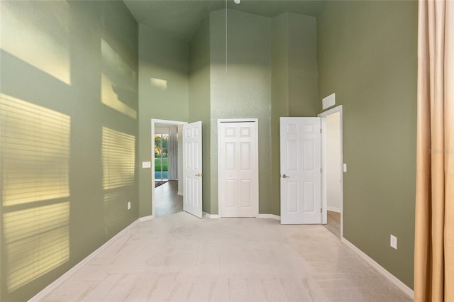 interior space featuring light carpet and high vaulted ceiling