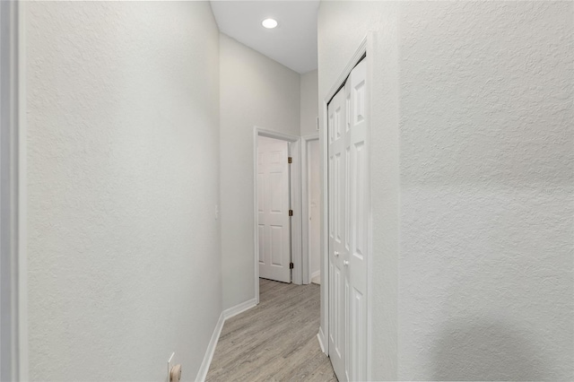 hallway with light hardwood / wood-style floors