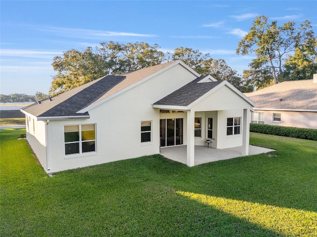 rear view of property featuring a yard and a patio area