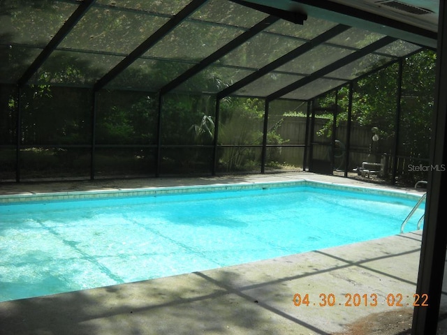 view of pool with glass enclosure