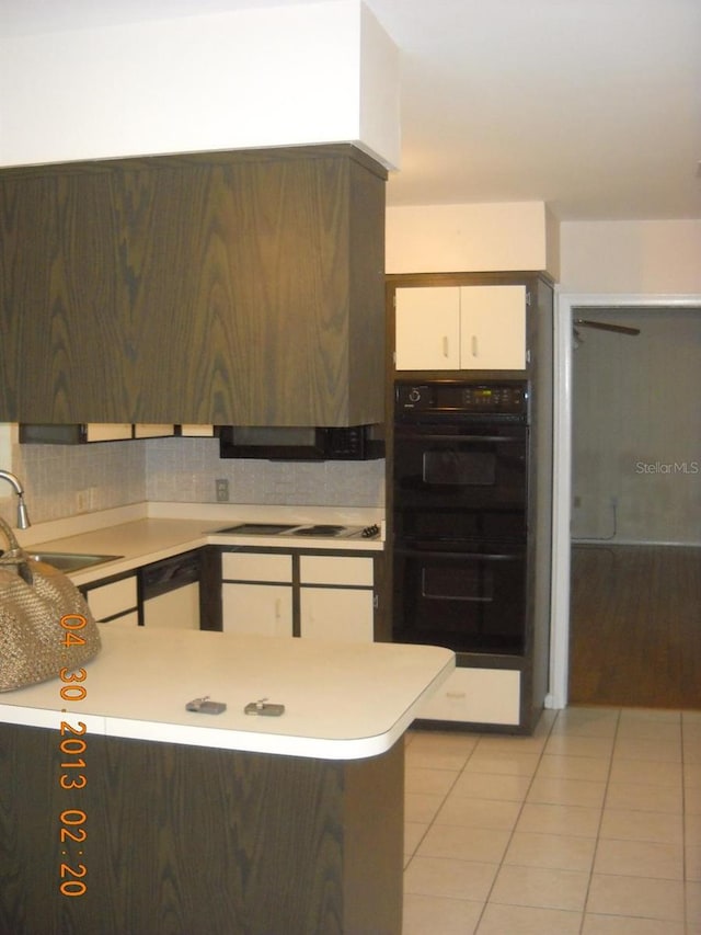 kitchen with sink, double oven, tasteful backsplash, light tile patterned flooring, and white cabinetry