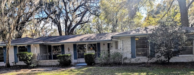 ranch-style home featuring brick siding and covered porch