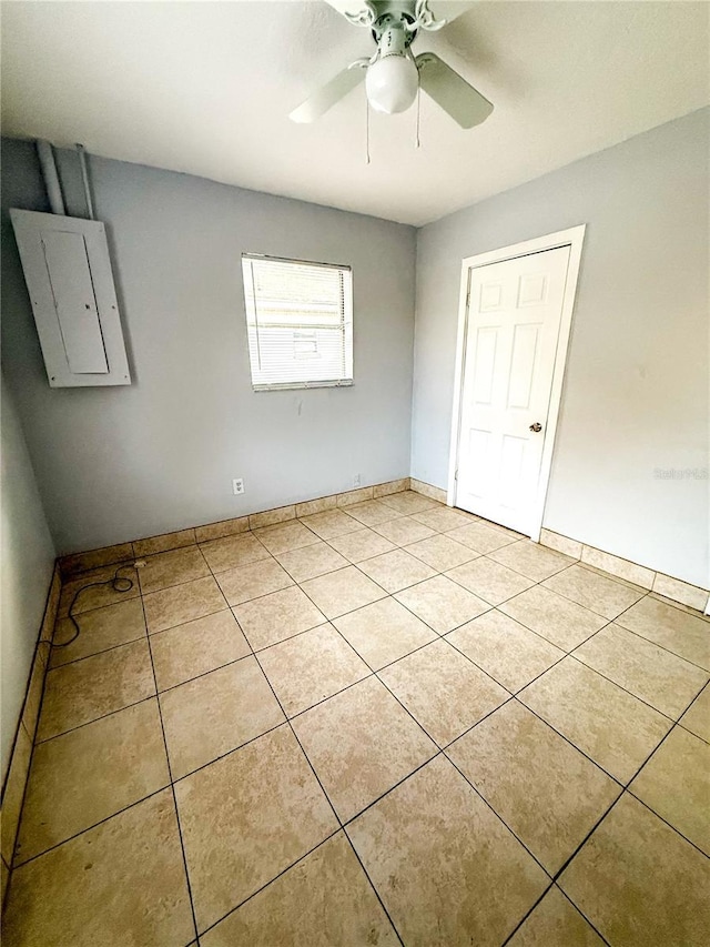 unfurnished bedroom with light tile patterned floors, a closet, electric panel, and ceiling fan