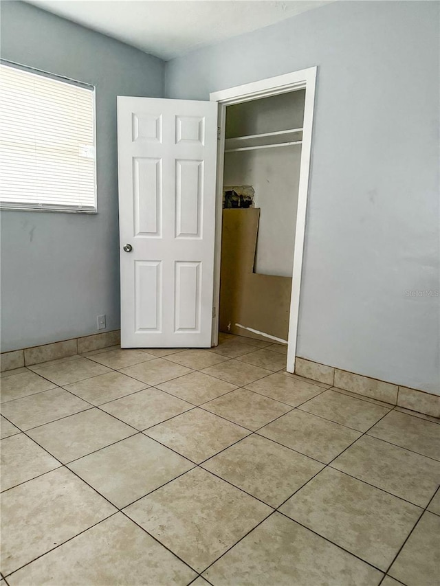 unfurnished bedroom with a closet and light tile patterned flooring