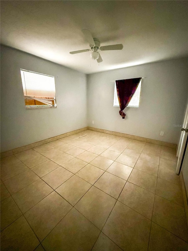 empty room with light tile patterned floors and ceiling fan