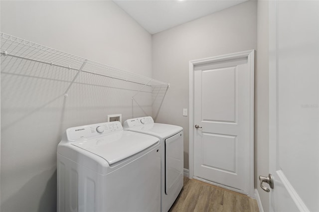 laundry area featuring washer and dryer and light hardwood / wood-style floors