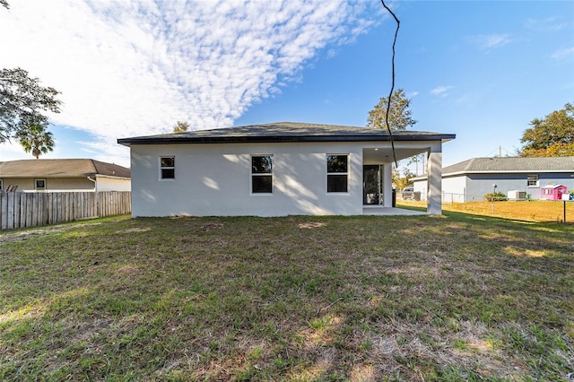 rear view of property featuring a yard, cooling unit, and a patio area