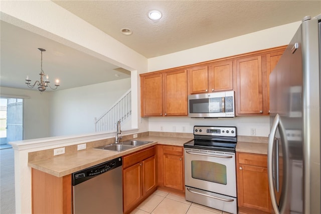 kitchen with hanging light fixtures, stainless steel appliances, light tile patterned floors, sink, and kitchen peninsula