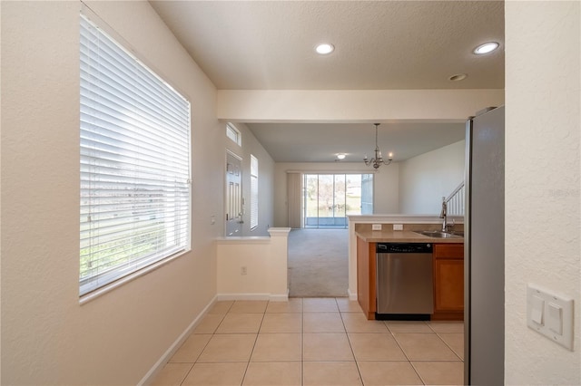 kitchen with an inviting chandelier, light tile patterned floors, sink, dishwasher, and hanging light fixtures