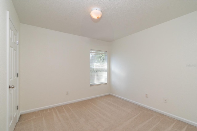 carpeted spare room featuring a textured ceiling