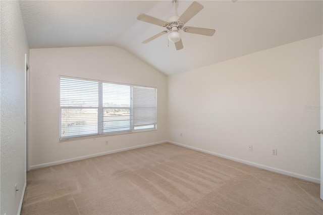 carpeted spare room featuring lofted ceiling and ceiling fan