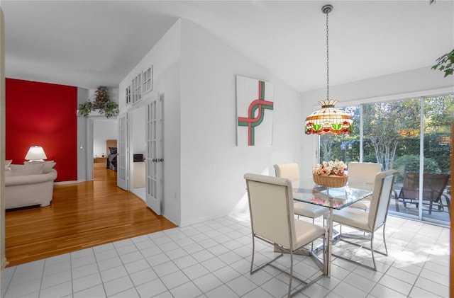 dining space with light hardwood / wood-style flooring and lofted ceiling