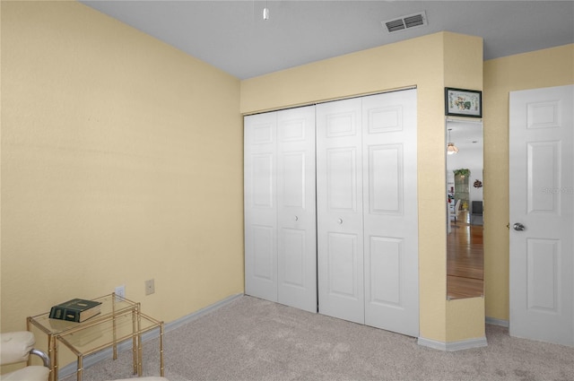 unfurnished bedroom featuring light carpet and a closet