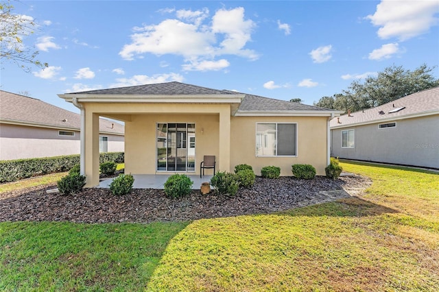 back of property with a lawn and a patio