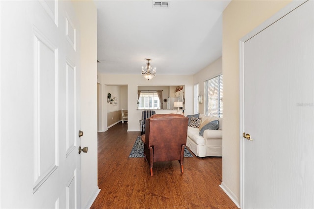 living room with dark hardwood / wood-style flooring and a chandelier