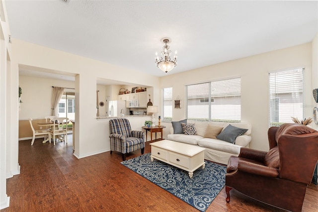 living room featuring dark wood-type flooring and a notable chandelier