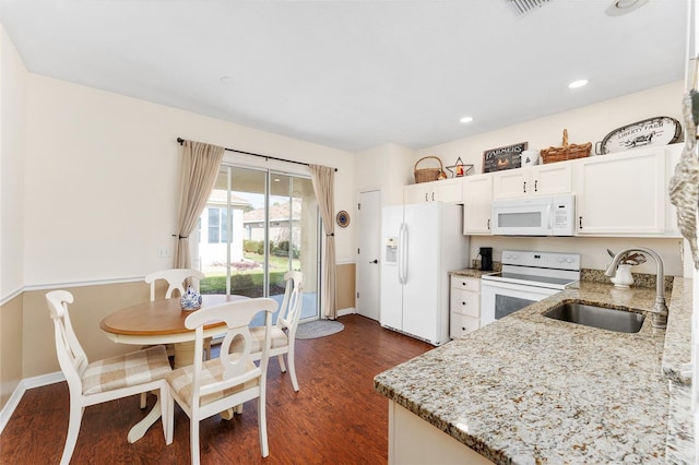 kitchen featuring dark hardwood / wood-style flooring, light stone counters, white appliances, sink, and white cabinetry