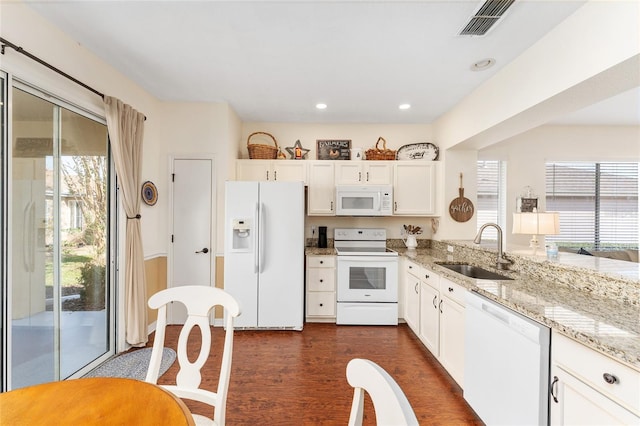 kitchen featuring white appliances, sink, a wealth of natural light, and dark wood-type flooring