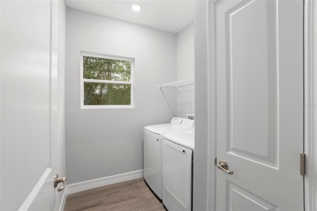 clothes washing area with light wood-type flooring and washer and clothes dryer