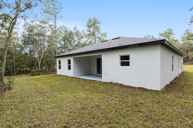 back of house with a patio area and a yard