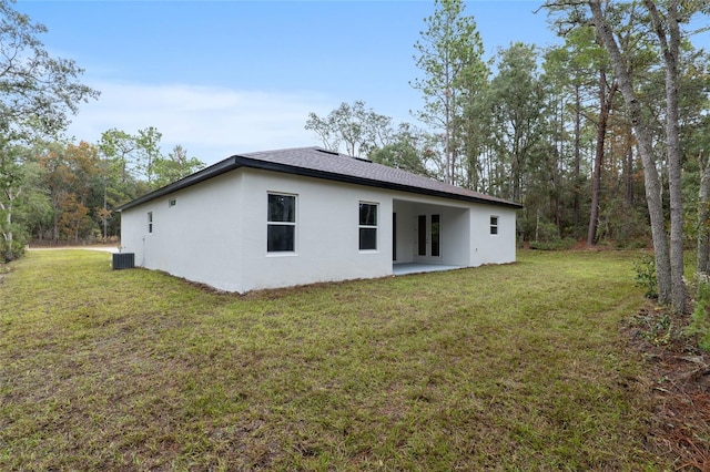 back of property featuring a yard, cooling unit, and a patio