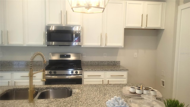 kitchen with white cabinets, light stone countertops, sink, and appliances with stainless steel finishes