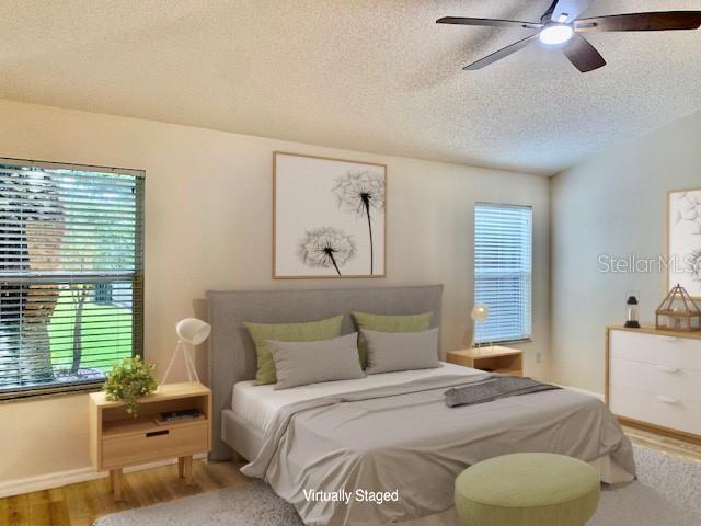 bedroom with ceiling fan, a textured ceiling, and hardwood / wood-style flooring