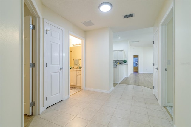 hall featuring light tile patterned flooring