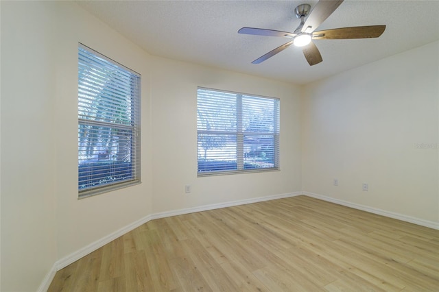 spare room with ceiling fan, light hardwood / wood-style flooring, and a textured ceiling