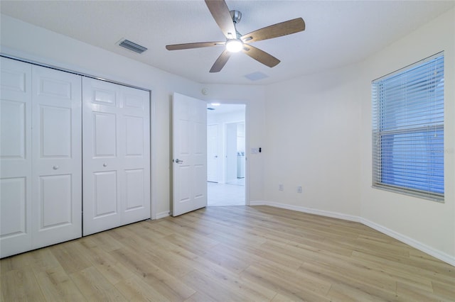 unfurnished bedroom featuring ceiling fan, a closet, and light hardwood / wood-style floors