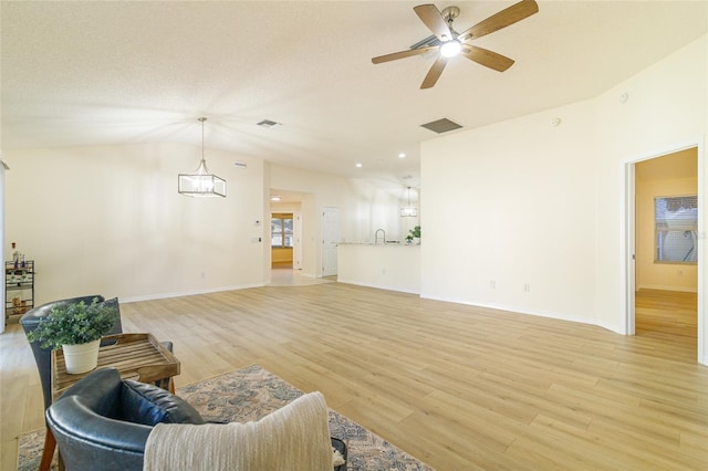 living room featuring ceiling fan, lofted ceiling, sink, and light hardwood / wood-style flooring