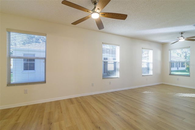 empty room featuring a textured ceiling, light wood-type flooring, and ceiling fan