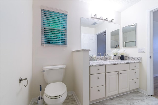 bathroom with vanity, a textured ceiling, and toilet