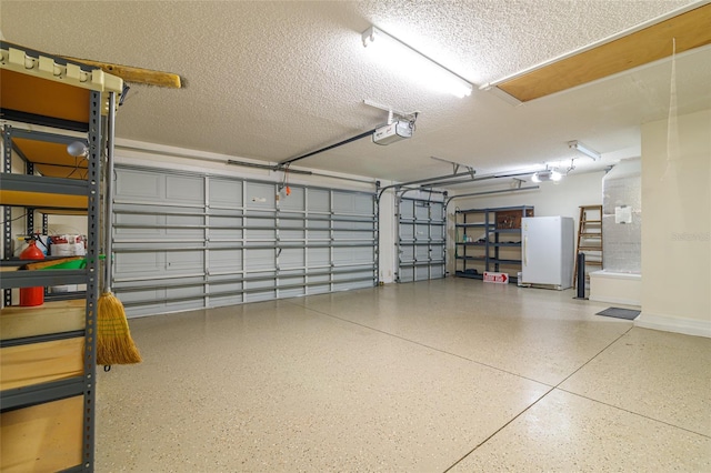 garage featuring white fridge and a garage door opener