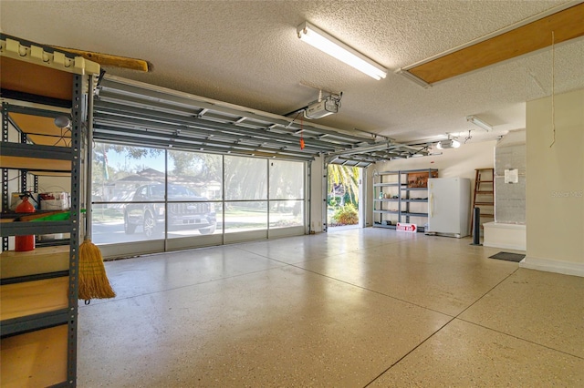 garage with white fridge and a garage door opener