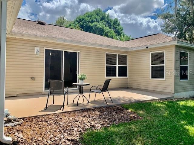 rear view of property with a yard and a patio area